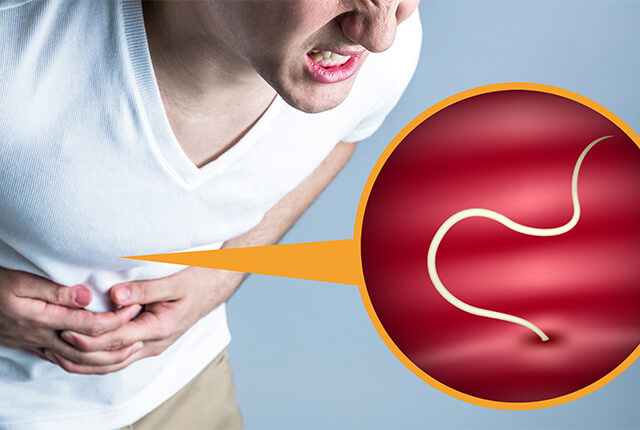 苦しそうに腹部を押さえている男性の画像とアニサキスをイメージしたイラスト