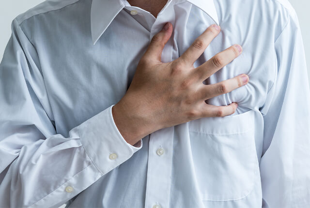 心臓を押さえている男性